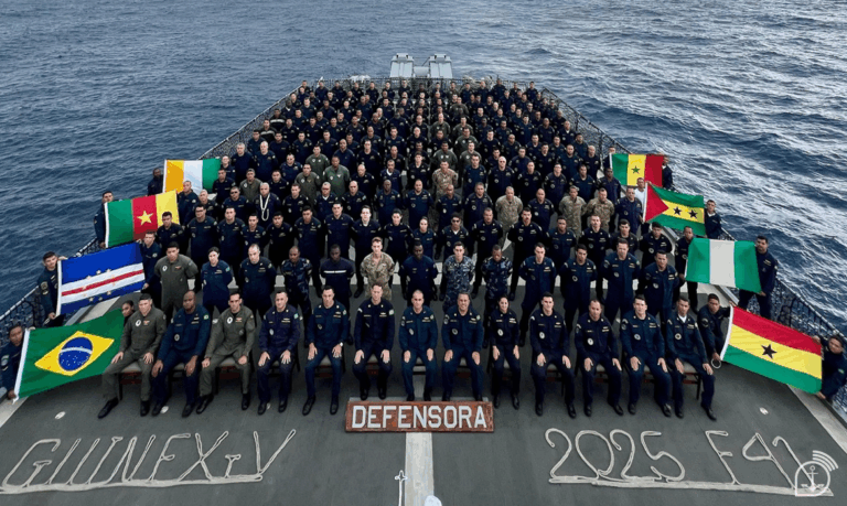 Tripulação militar e bandeiras em navio no mar.