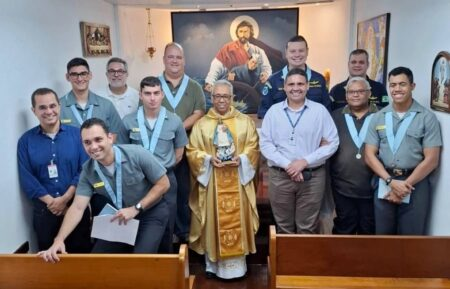 Grupo posando em igreja, padre ao centro.